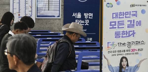 ‘더(The) 경기패스’ 홍보 입간판이 설치된 수원역에서 시민들이 개찰구를 통과하고 있는 모습. /경인일보DB