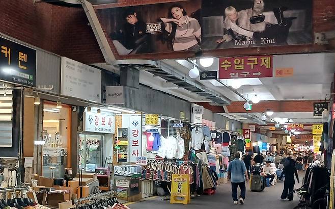 Billboards for fashion brands Marithe et Francois Girbaud and Matin Kim are seen at Gwangjang Market in central Seoul on Oct. 1. [KIM KYUNG-MI]