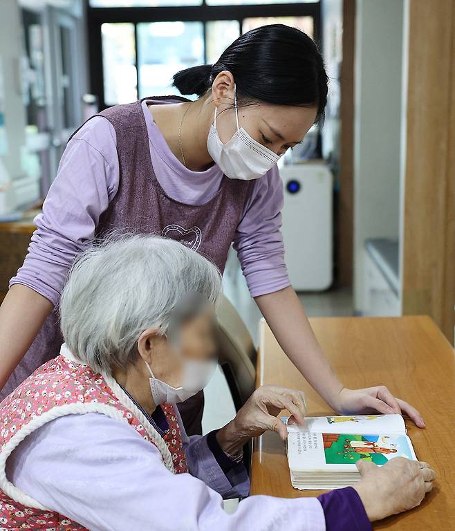 외국인 유학생 요양보호사 찬티안이 지난달 11일 경기 용인의 한 노인요양시설에서 노인과 함께 그림책을 읽고 있다. 용인=남정탁 기자