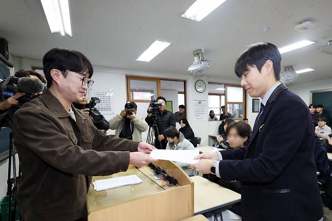 5일 광주 서구 화정동 서석고등학교에서 2026학년도 대학수학능력시험 만점자 재학생 최장우 군이 성적표를 받고 있다. /연합뉴스