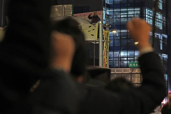 지난달 20일 저녁 서울 중구 세종호텔 앞에서 세종호텔 투쟁문화제가 열려 주먹질을 하는 참가자들 사이로 고공농성중인 고진수 지부장이 보이고 있다. 백소아 기자 thanks@hani.co.kr