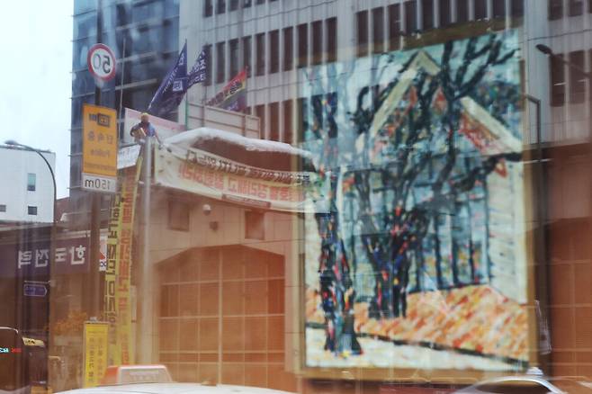 지난달 24일 아침 서울 중구 세종호텔 앞에서 세종문화 투쟁 아침선전전이 열려 세종호텔 1층 세종갤러리 창문에 고공농성중인 고진수 지부장의 모습이 반사되고 있다. 백소아 기자 thanks@hani.co.kr