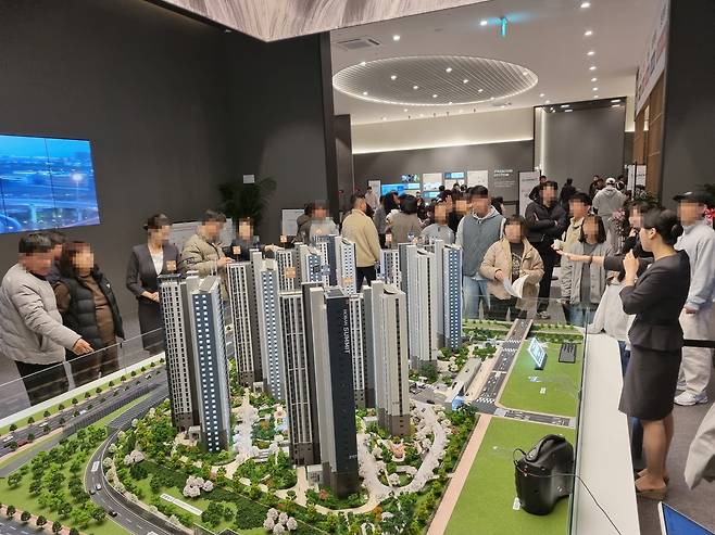 ‘호반써밋 인천검단 3차’ 견본주택 방문객들이 아파트 단지 모형을 살펴보고 있다. [호반건설 제공]