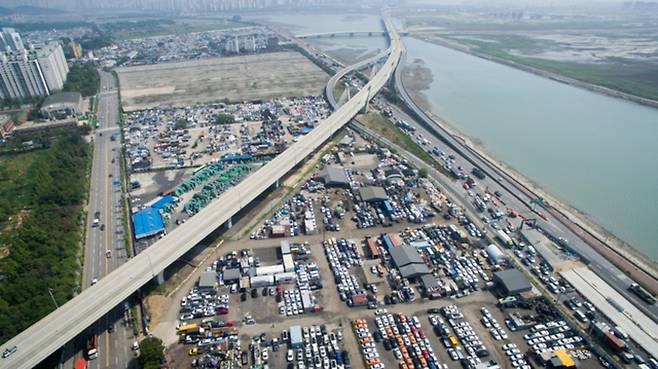 ▲ 인천 연수구 옛 송도유원지 도시개발 사업지 모습. 해당 구역에는 인천대교를 잇는 제2경인고속도로 사이에 수출용 중고차가 야적돼 있다. /인천일보DB