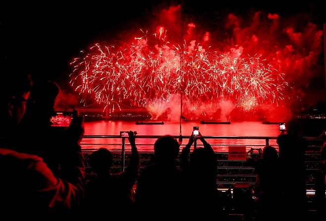 에어비앤비는 "고물가 등의 여파로 Z세대들 사이에 48시간 이내 국제여행이 인기를 끌고 있다"고 밝히면서 부산을 글로벌 Z세대들의 인기 여행지로 꼽았다. 지난 11월 부산 광안리해수욕장에서 열린 불꽃축제에서 관광객들이 사진을 찍고 있다. 연합뉴스