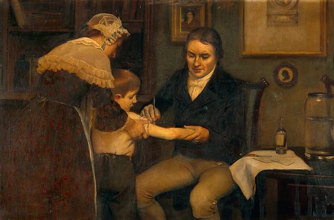 Imagined depiction of Edward Jenner administering the first smallpox vaccination. [WIKIPEDIA]