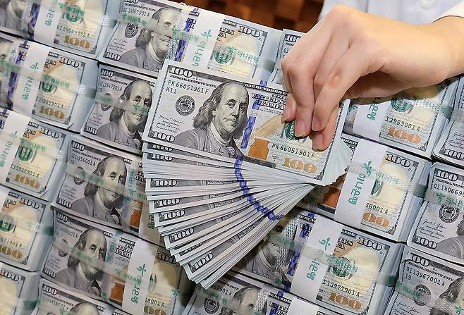 Dollar notes are held by a Hana Bank official at the bank's central Seoul branch in Jung District on Dec. 3. [NEWS1]