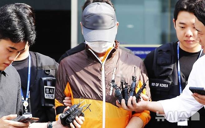 지난 7월30일 오전 인천 남동구 논현경찰서에서 사제총기로 아들을 살해한 혐의 등으로 경찰에 구속된 60대가 검찰에 송치되고 있다. [뉴시스]