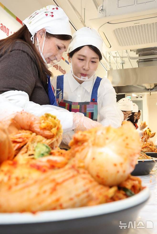 [서울=뉴시스] 고범준 기자 = 김혜경 여사가 9일 서울 종로구 북촌 한식문화공간 이음에서 열린 주한대사 배우자 초청 김장 행사에서 주한 외국대사 배우자들과 함께 김치를 담그고 있다. 2025.12.09. bjko@newsis.com