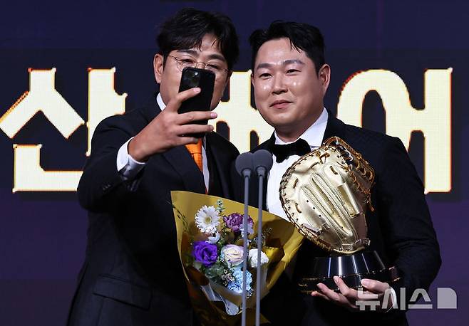 [서울=뉴시스] 최진석 기자 = 두산 양의지가 9일 서울 송파구 롯데호텔 월드에서 열린 '2025 KBO 골든글러브 시상식'에서 포수 골든글러브를 수상하며 정민철 해설위원과 기념촬영하고 있다. 2025.12.09. myjs@newsis.com