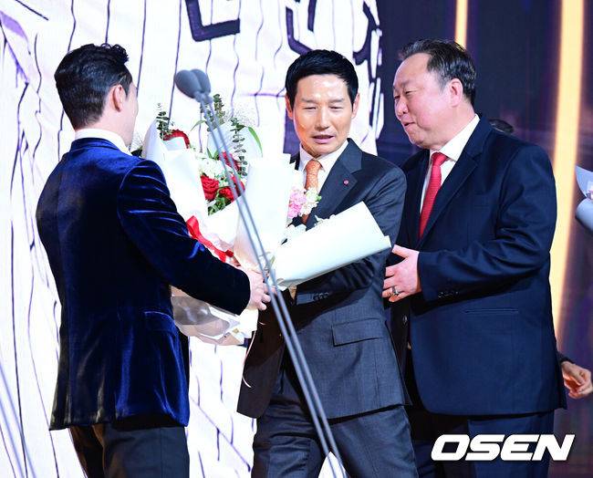 [OSEN=지형준 기자] 9일 오후 서울 송파구 잠실동 롯데호텔 월드에서 2025 신한은행 SOL 뱅크 KBO 골든글러브 시상식이 열렸다.KBO 골든글러브 시상식은 포지션별 최고의 선수를 가리는 자리로 올 시즌의 대미를 장식하는 자리다.&nbsp;LG 신민재가 2루수 부문 골든글러브를 수상하며 염경엽 감독, 차명석 단장의 축하를 받고 있다. 2025.12.09 /jpnews@osen.co.kr