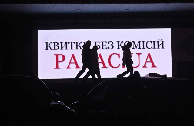 ▲7일(현지시간) 러시아가 우크라이나를 침공 중인 가운데 정전된 우크라 수도 키이우에서 주민들이 광고판 앞을 지나고 있다. ⓒAFP=연합뉴스