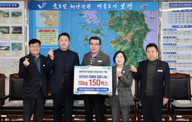 신보령 홍대령 대표(왼쪽 두번째)대표가 지난 11월 김동일 보령시장(사진 가운데)에게 사랑의 김장김치 150박스를 기탁하는 모습. 신보령(주) 제공