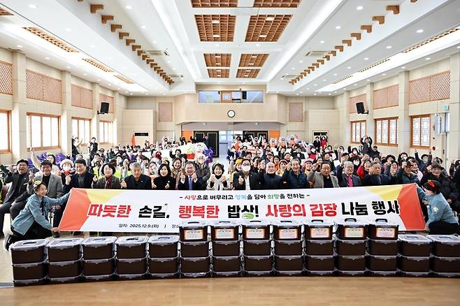 ▲ 대구 군위군은 9일 군위군민회관에서 '따뜻한 손길, 행복한 밥상 사랑의 김장 나눔 행사'를 열고, 담근 김치를 관내 경로당에 전달하는 나눔 행사를 가진 후 기념촬영을 하고 있다. 군위군