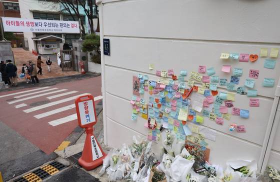 Notes expressing condolences for an elementary student who was killed by a drunk driver are seen attached on an outer wall of the child's school in December 2022. [YONHAP]
