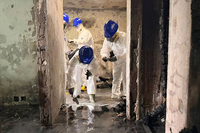 [홍콩=AP/뉴시스] ﻿﻿홍콩 북부 타이포 지역 고층 아파트에서 발생한 대형 화재 참사와 관련해, 사망자 수가 160명으로 증가했다고 홍콩 당국이 공식 발표했다. 사진은 경찰관들이 화재 현장에서 잔해를 수색하는 모습. 2025.12.10