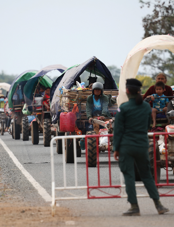 태국과 캄보디아 간의 무력 충돌을 피해 대피하는 사람들을 한 경찰관이 난민 캠프로 안내하고 있다. 오다르민체이 로이터 연합뉴스