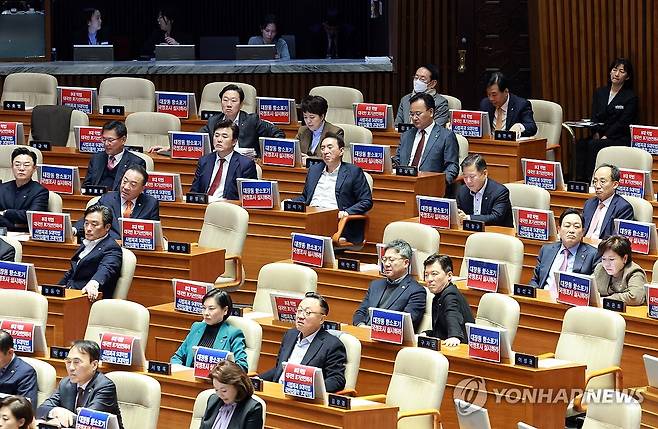 정부여당 비판 인쇄물 붙인 국민의힘 (서울=연합뉴스) 신현우 기자 = 9일 국회 본회의에서 국민의힘 나경원 의원이 가맹사업거래의 공정화에 관한 법률 일부개정법률안에 대해 무제한 토론을 하는 가운데 국민의힘 의원들 모니터에 대장동 항소포기 국정조사 실시와 '8대 악법' 대국민 포기 선언을 촉구하는 인쇄물이 붙어 있다.. 2025.12.9 nowwego@yna.co.kr