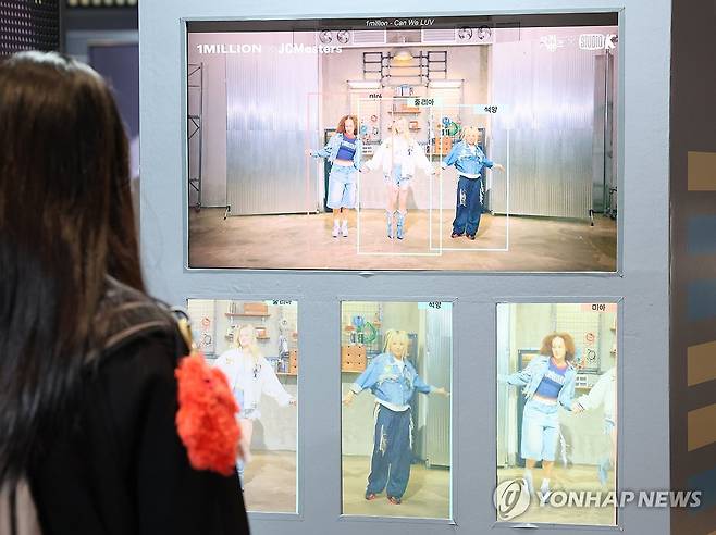 AI 활용한 영상들 12월 4일 서울 강남구 코엑스 더플라츠에서 열린 'AI콘텐츠 페스티벌'에서 참관객이 촬영본을 AI로 확장한 영상을 관람하고 있다. [연합뉴스 자료사진]