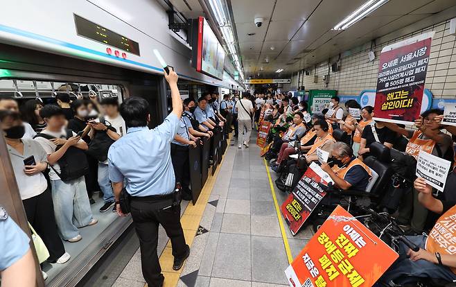 전국장애인차별철폐연대 회원들이 지난 9월 5일 오전 서울 종로구 혜화역에서 63차 ‘출근길 지하철 탑니다’ 투쟁집회를 하고 있다.  [뉴시스]