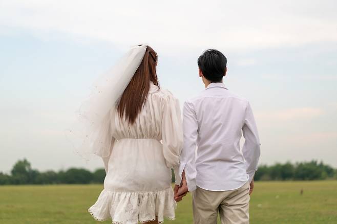 손을 잡고 걸어가는 연인의 뒷모습. 123rf