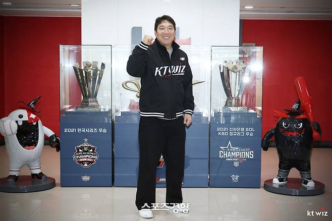 KT 위즈 김현수가 팀의 지난 시즌 우승 트로피 앞에서 각오를 다지며 포즈를 취하고 있다. KT 위즈 제공