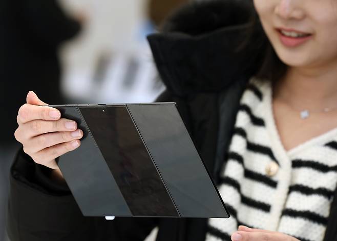 삼성전자가 12일 두 번 접는 형태의 폴더블 스마트폰 ‘갤럭시 Z 트라이폴드’의 국내 판매를 시작했다. 서울 강남구 매장에서 한 시민이 ‘갤럭시 Z 트라이폴드’를 둘러보고 있다. 연합뉴스