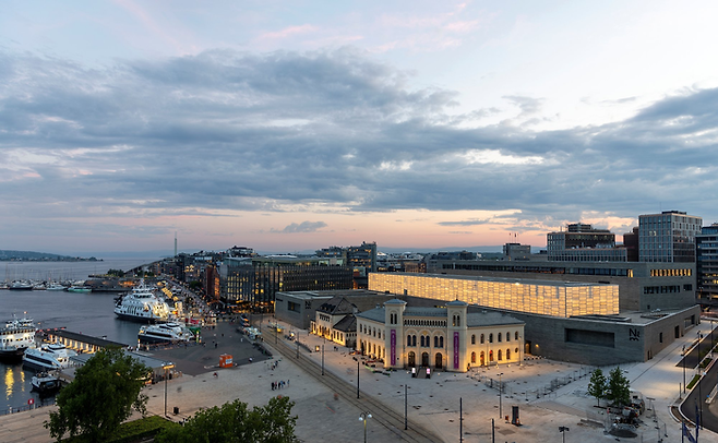 아케르 브뤼게의 입구에 자리 잡은 거대한 국립 미술관 불켜진 미술관의 정문 앞에 있는 고풍스러운 건물은 노벨 평화상을 수상하는 노벨 평화 센터다. ©Nasjonal Museet