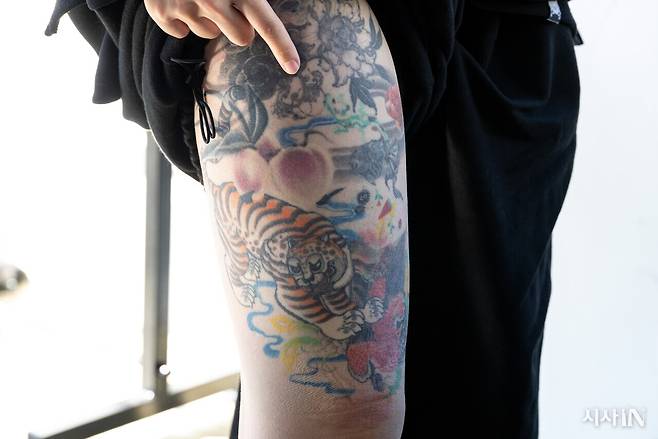 황도씨가 자신의 몸에 새긴 타투를 보여주고 있다. 복숭아 타투가 가장 가운데 자리 잡고 있다. ⓒ시사IN 신선영