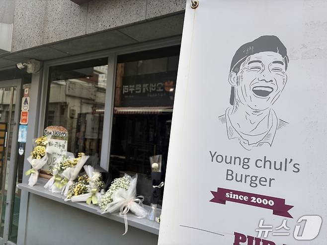 14일 오전 서울 성북구 안암동에 있는 영철버거 앞에 흰 꽃다발이 줄지어 놓였다. 2025.12.14/ 뉴스1 김종훈 기자