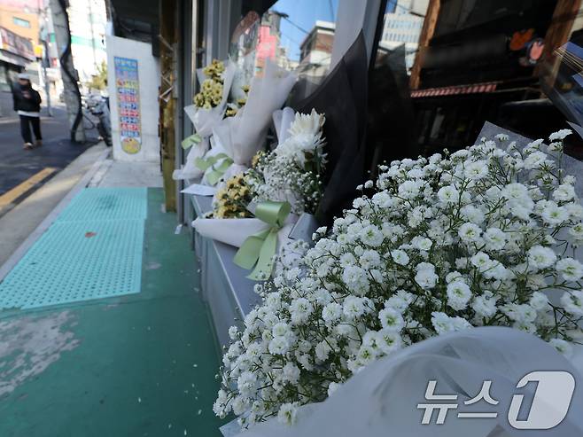 14일 오전 서울 성북구 안암동 영철버거 앞에 영철버거 대표 이영철 씨의 별세 소식을 추모하는 꽃이 놓여져 있다.   2025.12.14/뉴스1 ⓒ News1 황기선 기자