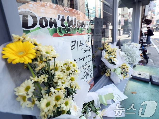 14일 오전 서울 성북구 안암동 영철버거 앞에 영철버거 대표 이영철 씨의 별세 소식을 추모하는 꽃이 놓여져 있다.   2025.12.14/뉴스1 ⓒ News1 황기선 기자