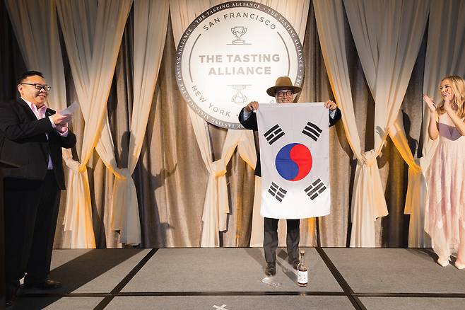 지난달 10일 ‘샌프란시스코 세계주류경연대회(SFWSC) 2025’에서 상을 받은 뒤 태극기를 꺼낸 도정한 대표. SFWSC 누리집 화면 갈무리