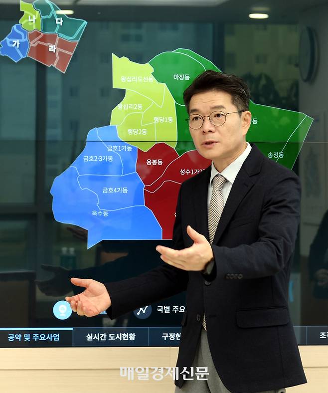 정원오 성동구청장이 지난 11일 성동구청사에서 공약 추진 상황이 적힌 스크린 보드를 앞에 두고 설명하고 있다. [사진=김재훈 기자]