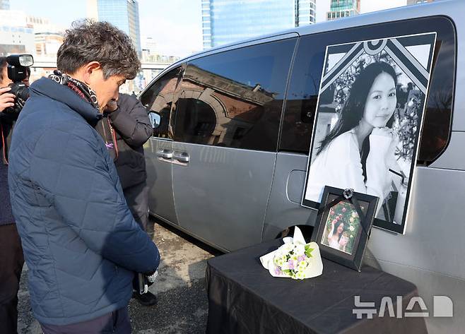 [서울=뉴시스] 이영환 기자 = 14일 오후 서울 용산구 서울역 앞에서 열린 2025 세계 이주노동자의 날 기념 전국이주노동자대회에서 참석자가 고 뚜안씨를 추모하고 있다.  2025.12.14. 20hwan@newsis.com