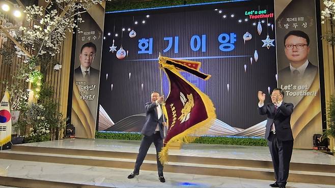 포항 대동고등학교 총동문회 제24대 방두성(왼쪽) 회장이 전임 회장인 김성수 회장과 함께 동문회기를 힘차게 흔들고 있다.&nbsp;