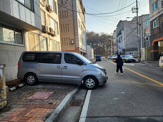 15일 오전 충북 청주시 흥덕구 봉명동의 한 빌라 밀집 지역에 인도와 차도를 점거해 차량이 주차돼 있다. 주차된 차량을 피해 시민이 차도로 걸어가고 있다. 사진=송휘헌 기자&nbsp;hhsong@cctoday.co.kr