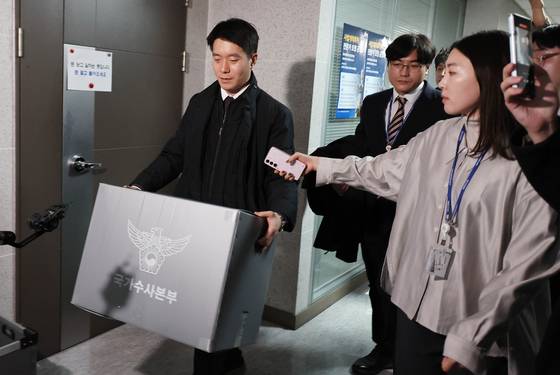 경찰청 국가수사본부 특별전담수사팀 관계자가 15일 오후 서울 여의도 국회 의원회관에 있는 전재수 더불어민주당 의원의 사무실에서 압수수색을 마친 뒤 압수물을 들고 이동하고 있다. 임현동 기자