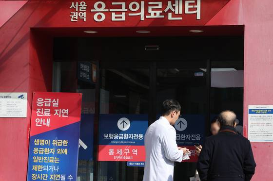 Medical staff talks to a patient's family member in front of a university hopsital in Seoul on Feb. 5. [NEWS1]