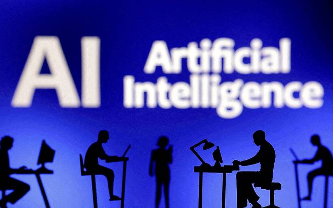Figurines with computers and smartphones are seen in front of the words ″Artificial Intelligence AI″ in this illustration created on Feb. 19, 2024. [REUTERS/YONHAP]