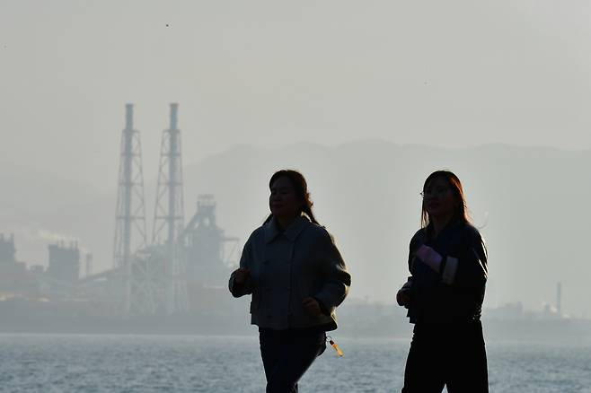 Citizens run along a coastal road in Buk District, Pohang, North Gyeongsang, on Dec. 10, as fine dust levels in the area reached around 60 micrograms per cubic meter. [NEWS1]