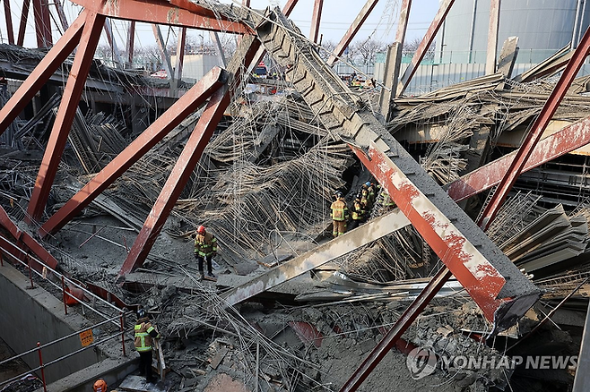지난 11일 오후 광주 서구 치평동 광주대표도서관 건립공사장에서 붕괴 사고가 발생해 소방대원들이 매몰자 구조 작업을 벌이고 있다. 연합뉴스