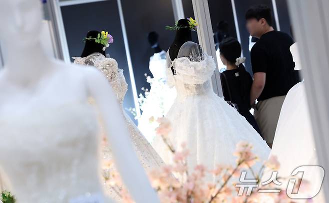 지난 7월 6일 서울 강남구 삼성동 코엑스에서 열린 2025 추계 웨덱스 웨딩 박람회에서 예비 부부들이 전시된 드레스를 살펴보고 있다. 2025.7.6/뉴스1 ⓒ News1 김성진 기자
