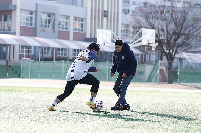 김천상무가 연고지역 내 김천고등학교에서 '오슈웅 축구교실'을 진행한 뒤 학생들과 기념사진을 찍었다. 일일코치로 변신한 김주찬(오른쪽)이 드리블을 지도하고 있다. 사진제공=김천 상무FC