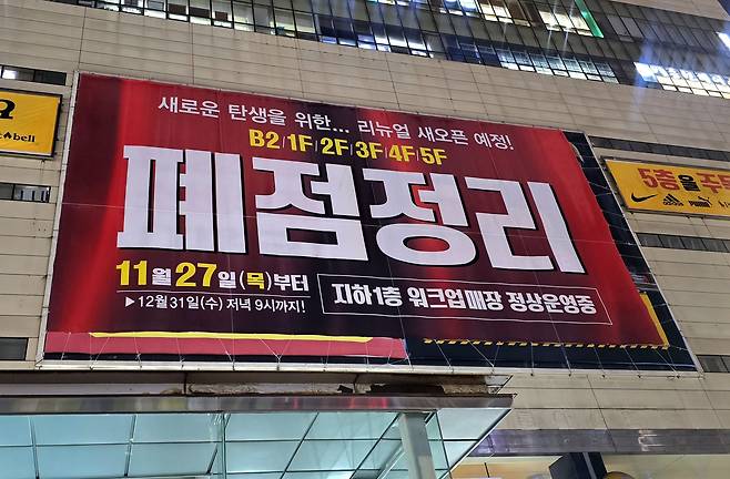 A ″closing down″ banner is hung outside the Raboum Outlet near Seoul National University in Gwanak District, southern Seoul, on Dec. 8. [NOH YU-RIM]