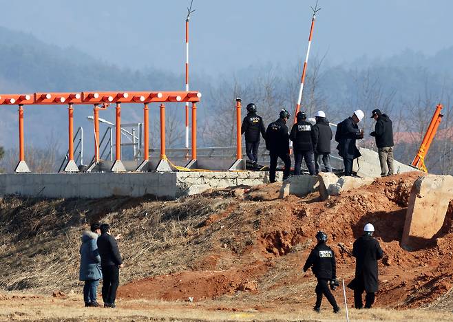 Investigators including officials from the Aviation and Railway Accident Investigation Board, police and families of the victims of the Jeju Air crash inspect a localizer at Muan International Airport in South Jeolla on Feb. 26. [YONHAP]
