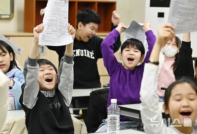 [수원=뉴시스] 김종택 기자 = 겨울방학식이 열린 16일 경기 수원시 영통구 잠원초등학교에서 4학년8반 학생들이 방학안내문을 들어보이고 있다. 2025.12.16. jtk@newsis.com