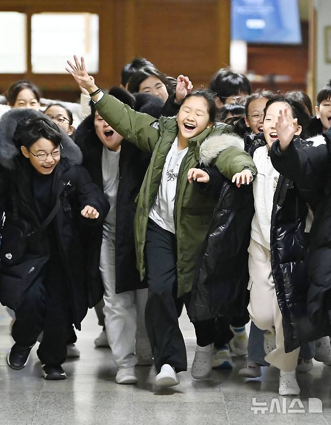 [수원=뉴시스] 김종택 기자 = 겨울방학식이 열린 16일 경기 수원시 영통구 잠원초등학교에서 4학년8반 학생들이 환하게 웃으며 하교하고 있다. 2025.12.16. jtk@newsis.com