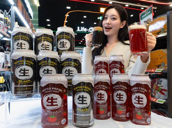 모델이 세븐일레븐에서 투명캔 생맥주 생드래프트블랙와 생드래프트레드를 소개하고 있다. [사진=세븐일레븐]