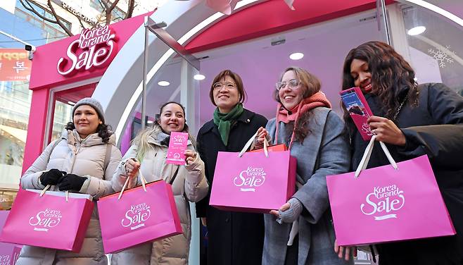 Tourists to Korea and Culture Ministry's Second Vice Minister Jang Mi-ran, middle, attend the 2025 Korea Grand Sale in Jung District, central Seoul, on Jan. 15. [NEWS1]
